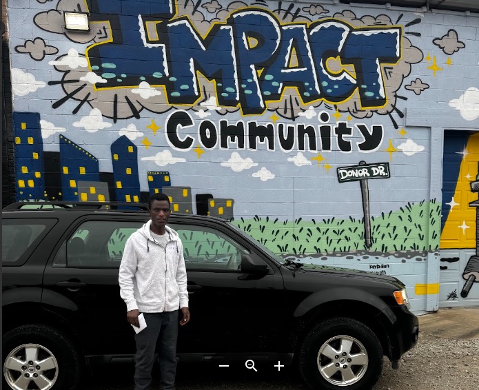 Karaha with his vehicle at Impact Garage